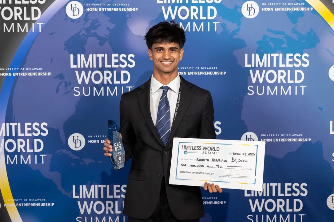 Ashmith Yaramada holding the Emerging Innovator Finalist trophy and $1,000 check at the Limitless World Summit