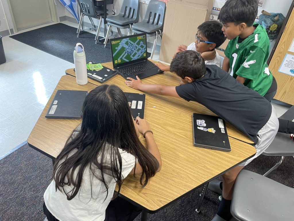 Mini Makers students coding together at a laptop during a class session